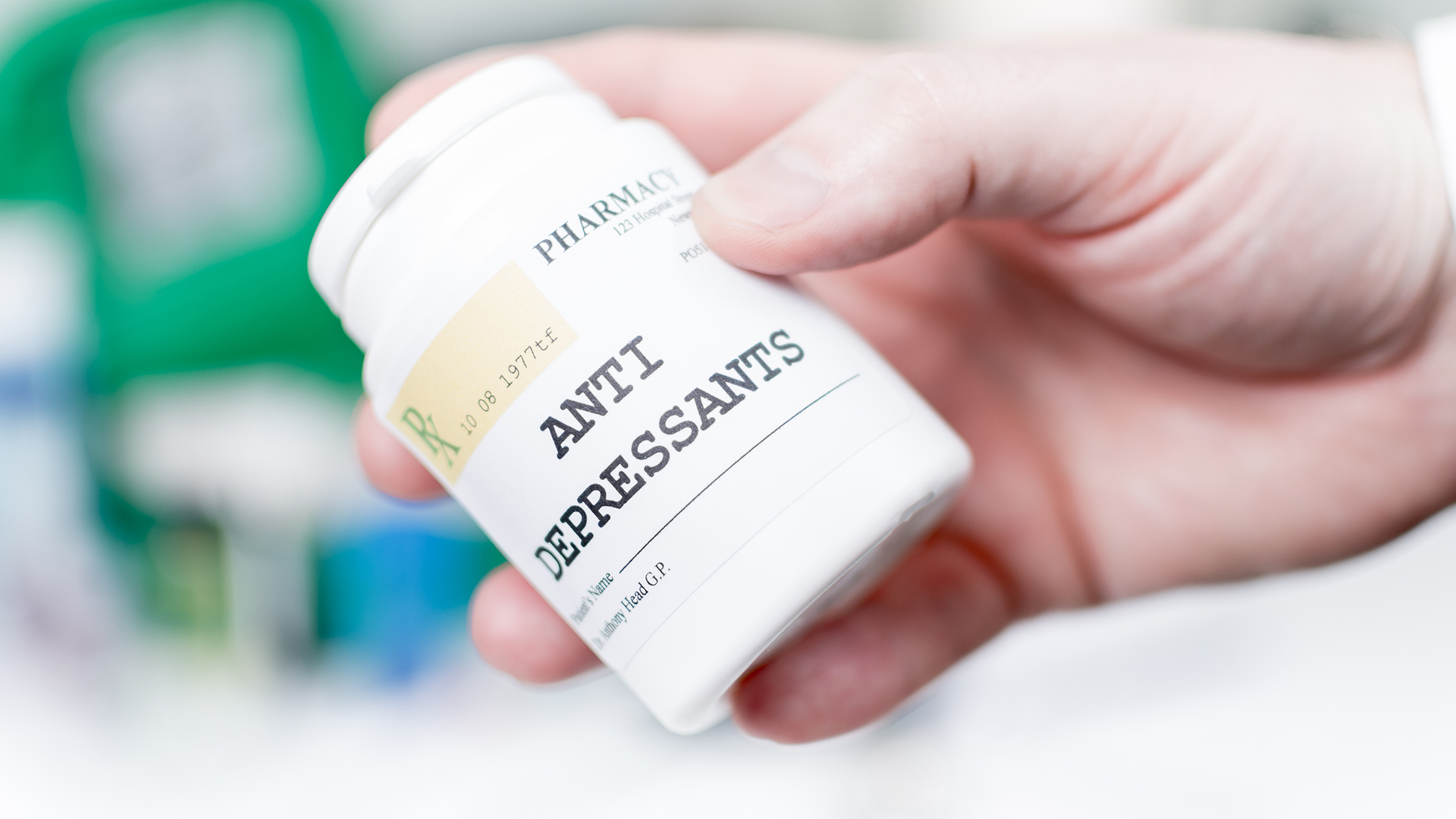 Рука держит флакон с таблетками с надписью Antidepressants на аптечной этикетке